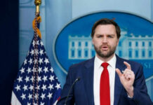 VP Vance Targets Democrats in Fiery Speech Man speaking at podium with US flag behind