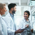 Evolution Revolution – Sponges Were First! Three scientists discussing work at a glass board
