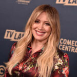 A smiling woman in a floral dress at a TV Land event