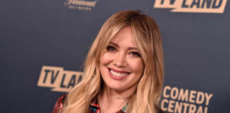 A smiling woman in a floral dress at a TV Land event