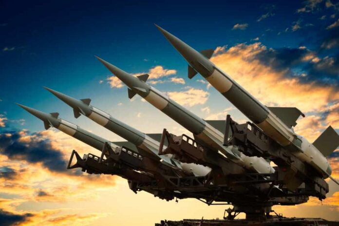 Cruise missile launcher with missiles pointed upwards against a sunset sky