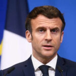 Middle East Tensions SOAR as France Deploys Fleet Man speaking at press conference with flags behind