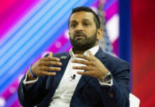 Person speaking on stage with colorful background