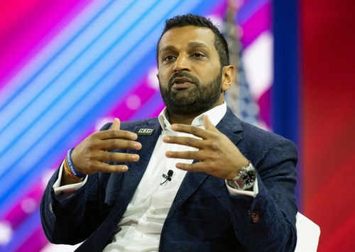 kash-patel2270821403 Person speaking on stage with colorful background