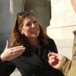 Taxpayer-Funded Cover-Ups Spark Public Fury Woman speaking outside during an interview with microphone