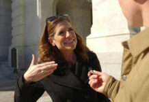 Taxpayer-Funded Cover-Ups Spark Public Fury Woman speaking outside during an interview with microphone