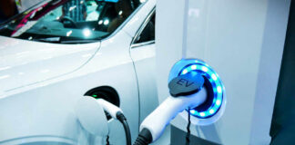 Electric vehicle charging at a station with a white car in the background