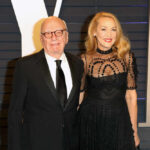 A couple dressed in formal attire posing together at a red carpet event