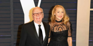 A couple dressed in formal attire posing together at a red carpet event