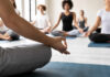 Participants in a yoga class practicing meditation on mats