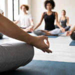 Participants in a yoga class practicing meditation on mats
