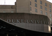 Sign displaying 'Duke University' on a modern building