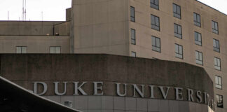 Sign displaying 'Duke University' on a modern building