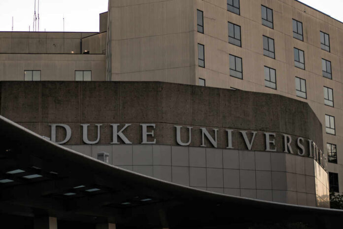 Sign displaying 'Duke University' on a modern building