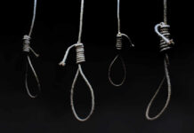 Four nooses hanging against a dark background