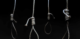 Four nooses hanging against a dark background