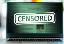 A laptop screen displaying a 'CENSORED' label over blurred content