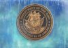 Bronze seal of the Department of the Navy against a blue background