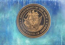 Bronze seal of the Department of the Navy against a blue background