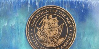 Bronze seal of the Department of the Navy against a blue background