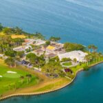 Aerial view of a coastal property with luxury homes and a golf course