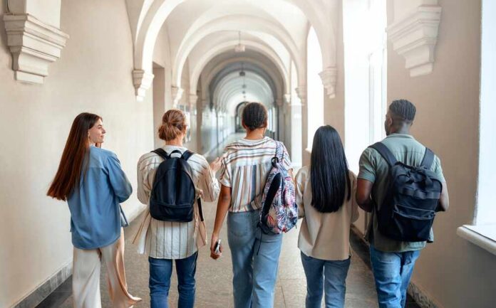 Group of students walking through a university corridor