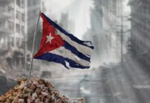 Worn Cuban flag standing on rubble in a desolate urban environment