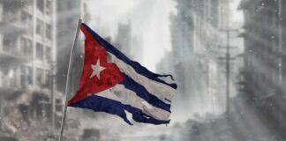 Worn Cuban flag standing on rubble in a desolate urban environment
