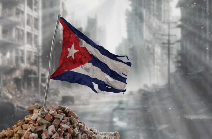 shutterstock_2548625383.jpg Worn Cuban flag standing on rubble in a desolate urban environment