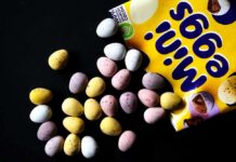 Colorful chocolate eggs scattered around a yellow packaging