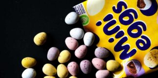 Colorful chocolate eggs scattered around a yellow packaging