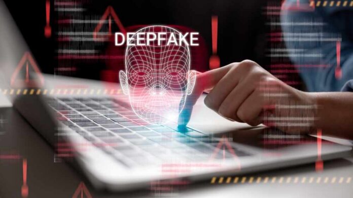 A hand interacting with a laptop displaying a deepfake warning