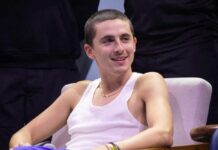 A young man in a tank top smiling while seated in an interview setting