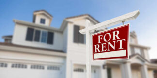 A 'For Rent' sign in front of a house