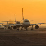 CEOs’ Bold Move: Congress Shutdown Slammed Airplanes lined up on a runway during sunset