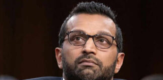 Man wearing glasses in a suit looking thoughtful