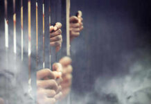 Hands gripping prison bars in smoky atmosphere