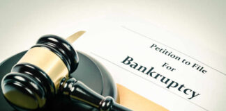 A gavel resting on a legal document titled 'Petition to File For Bankruptcy'