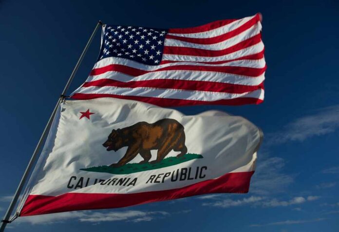 American and California flags waving against a blue sky