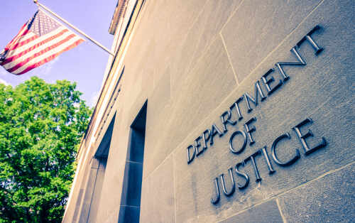 Exterior view of the Department of Justice building with an American flag
