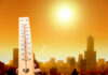 Thermometer displaying high temperature against a sunset city skyline