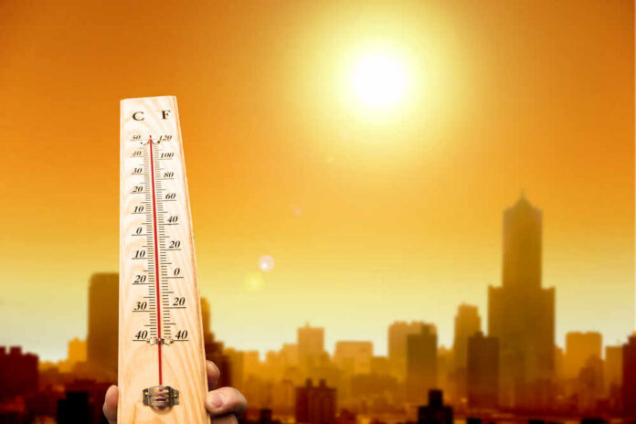 Thermometer displaying high temperature against a sunset city skyline