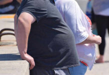 Two people leaning against a railing in an outdoor setting