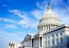 The U.S. Capitol building with an American flag flying under a blue sky