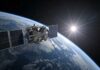 Satellite Blackout: What’s Trump Hiding in Iran? Satellite orbiting Earth with solar panels and the sun in the background