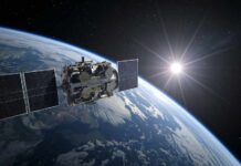 Satellite orbiting Earth with solar panels and the sun in the background