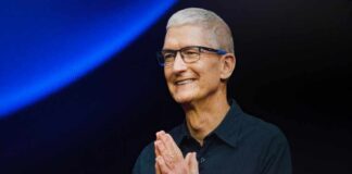 CEO presenting at a technology event with hands clasped in a welcoming gesture