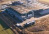 Data Centers INVADE—Who Picks Up the Tab? Aerial view of a large industrial facility with various structures and equipment