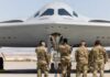 Military personnel inspecting a stealth bomber aircraft