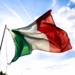 Italian flag waving against a blue sky